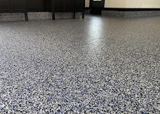Close, low-angle view of a glossy dark gray flake-coated floor