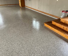Glossy gray flake-coated garage floor with wooden entry steps