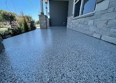 Front walkway with a gray and black flake coating alongside a stone-veneer home